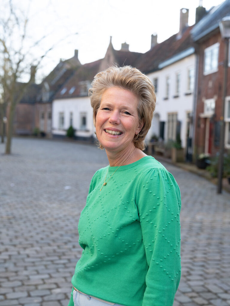 Portret van Corina in een rustige en huiselijke omgeving Portretfoto van Corina, het gezicht achter CorinaCare, in een rustige omgeving.